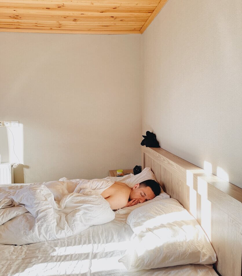 A cozy bedroom scene with someone sleeping peacefully, highlighting the benefits of tips from The Comprehensive Sleep Hack.