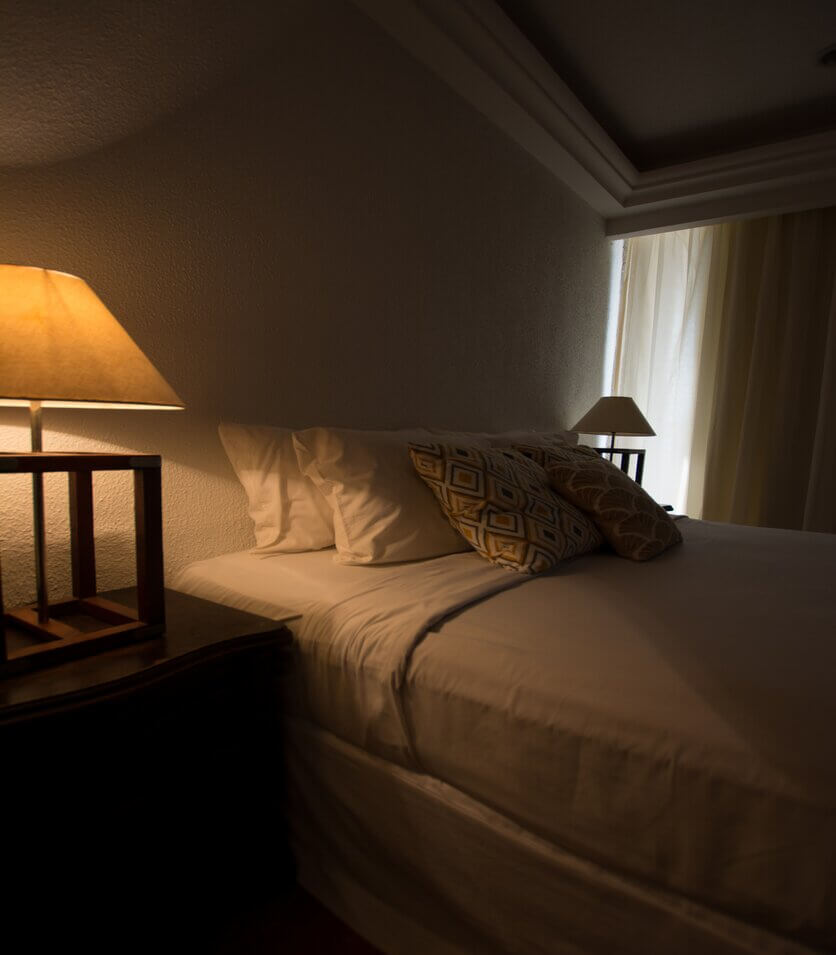 A comfortable, softly lit bedroom showcasing an ideal sleep environment, reflecting the guide’s tips on creating a restful space.